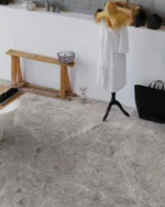 Pardoseală de baie din gresie porțelanată Maine Acero 60x120, marmură gri-oțel, alături de o bancă din lemn